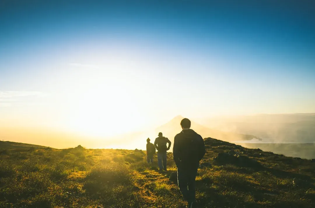 hiker on a trail with a breathtaking sunset view in the background