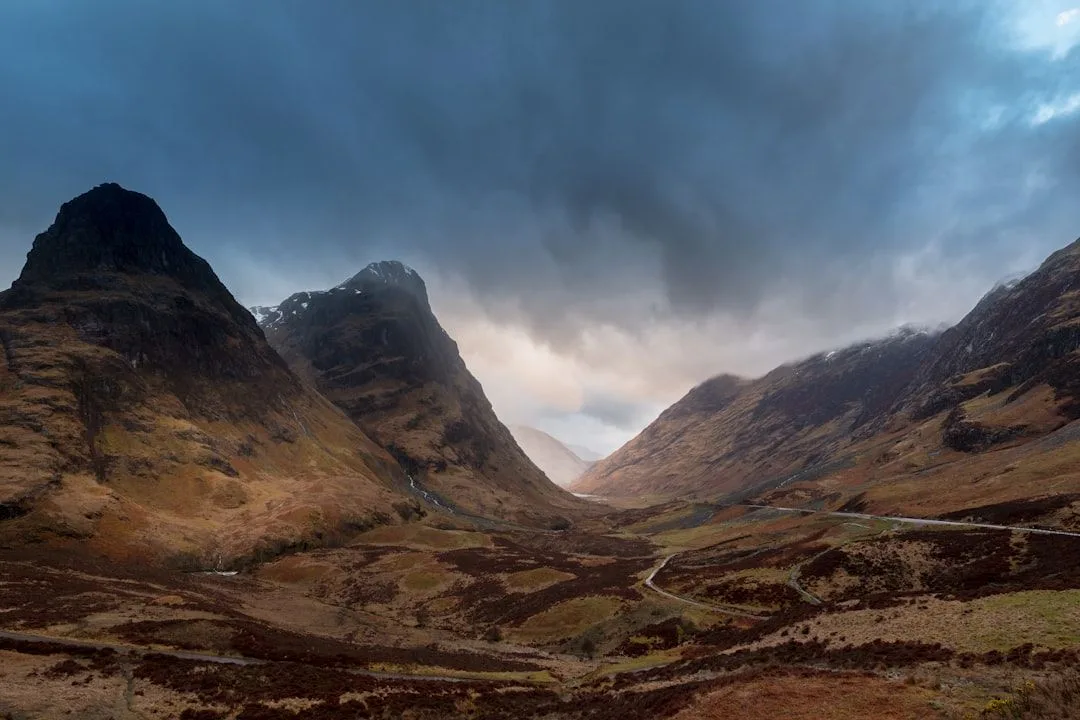The steep sided mountains of Glencoe in the Scottish Highlands under moody cloud